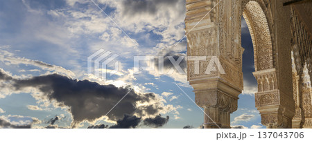 Arches in Islamic (Moorish) style (against the background of a beautiful sky with clouds) in Alhambra, Granada, Spain Arches in Islamic (Moorish) style (against the background of a beautiful sky with clouds) in Alhambra, Granada, Spain 137043706