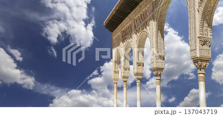 Arches in Islamic (Moorish) style (against the background of a beautiful sky with clouds) in Alhambra, Granada, Spain 137043719