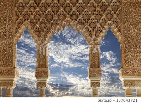 Arches in Islamic (Moorish) style (against the background of a beautiful sky with clouds) in Alhambra, Granada, Spain Arches in Islamic (Moorish) style (against the background of a beautiful sky with clouds) in Alhambra, Granada, Spain 137043721