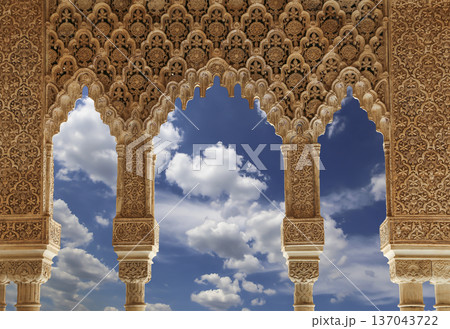 Arches in Islamic (Moorish) style (against the background of a beautiful sky with clouds) in Alhambra, Granada, Spain Arches in Islamic (Moorish) style (against the background of a beautiful sky with clouds) in Alhambra, Granada, Spain 137043722
