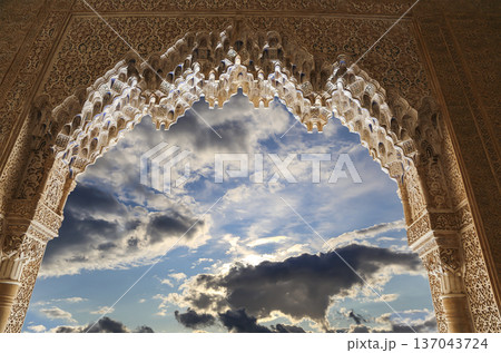 Arches in Islamic (Moorish) style (against the background of a beautiful sky with clouds) in Alhambra, Granada, Spain Arches in Islamic (Moorish) style (against the background of a beautiful sky with clouds) in Alhambra, Granada, Spain 137043724