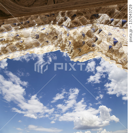 Arches in Islamic (Moorish) style (against the background of a beautiful sky with clouds) in Alhambra, Granada, Spain 137043729