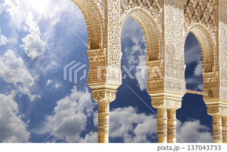 Arches in Islamic (Moorish) style (against the background of a beautiful sky with clouds) in Alhambra, Granada, Spain 137043733