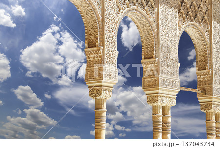 Arches in Islamic (Moorish) style (against the background of a beautiful sky with clouds) in Alhambra, Granada, Spain 137043734