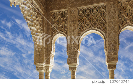 Arches in Islamic (Moorish) style (against the background of a beautiful sky with clouds) in Alhambra, Granada, Spain Arches in Islamic (Moorish) style (against the background of a beautiful sky with clouds) in Alhambra, Granada, Spain 137043744