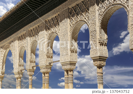 Arches in Islamic (Moorish) style (against the background of a beautiful sky with clouds) in Alhambra, Granada, Spain 137043752