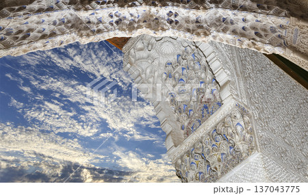 Arches in Islamic (Moorish) style (against the background of a beautiful sky with clouds) in Alhambra, Granada, Spain Arches in Islamic (Moorish) style (against the background of a beautiful sky with clouds) in Alhambra, Granada, Spain 137043775