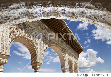 Arches in Islamic (Moorish) style (against the background of a beautiful sky with clouds) in Alhambra, Granada, Spain 137043781