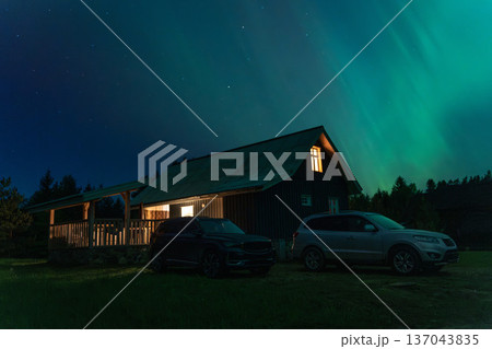 BRASLAV, BELARUS - 25 SEPTEMBER 2025: The northern lights (aurora borealis) in the night sky over Belarus. A beautiful scenic view of the colorful lights above a rural house 137043835