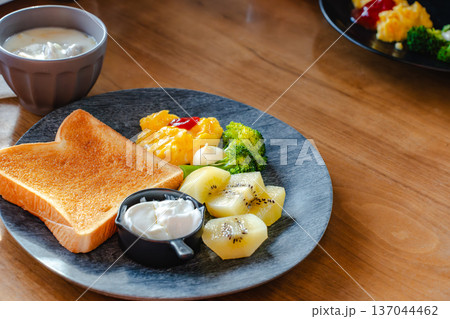 フルーツ付き朝食ワンプレート トーストとスクランブルエッグとキウイとブロッコリー 137044462