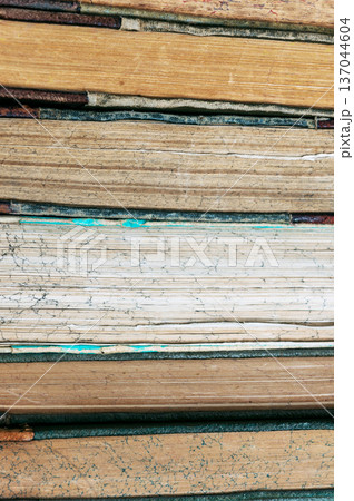 Stack of old books close up. Books in a row or stacked. Vintage or retro books. 137044604
