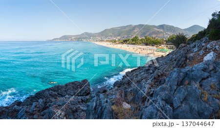Awesome panoramic view on sea coast and mountains. Tourists beach in Turkey, Alanya. Clear sunny day with rocky beach and seaside and turquoise water Awesome panoramic view on sea coast and mountains. Tourists beach in Turkey, Alanya. Clear sunny day with rocky beach and seaside and turquoise water 137044647