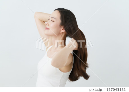 ロングヘアの髪の毛をかきあげる若い日本人女性　ビューティ 137045181