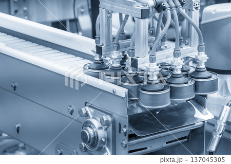 Automated vacuum robot performing high-speed material handling of tin can food on a conveyor belt in a hygienic food processing facility. 137045305