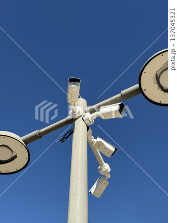 Surveillance cameras on pole with clear blue sky background emphasize security concept Surveillance cameras on pole with clear blue sky background emphasize security concept 137045321