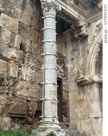 Ancient architectural column with stone wall background, showcasing historical and cultural heritage 137045337