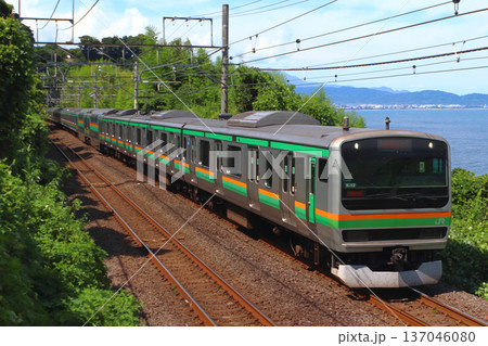 海沿いを行く東海道線E231系電車 137046080