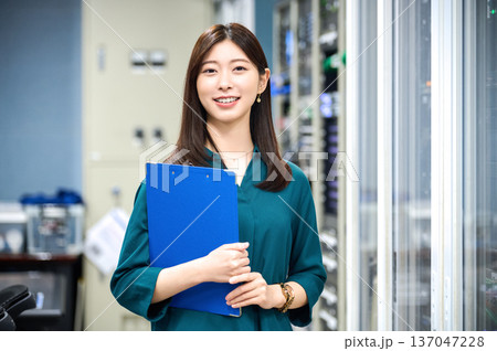 放送局の調整室でバインダーを持つ笑顔の日本人女性スタッフ 20撮影協力:スカパー東京メディアセンター 放送局の調整室でバインダーを持つ笑顔の日本人女性スタッフ 20撮影協力:スカパー東京メディアセンター 137047228