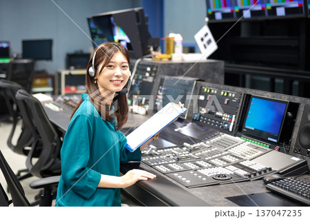 放送スタジオでインカムを使い指示を出す女性ディレクター　撮影協力:スカパー東京メディアセンター 137047235