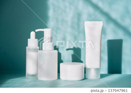 Skincare product packaging mockup on teal background with shadows 137047961