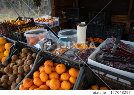Market stall with churchkhela sweets, mandarins, kiwifruit, and citrus fruits arranged in crates with natural colors and rustic textures. Food marketing, culinary tourism, local product promotion Market stall with churchkhela sweets, mandarins, kiwifruit, and citrus fruits arranged in crates with natural colors and rustic textures. Food marketing, culinary tourism, local product promotion 137048297