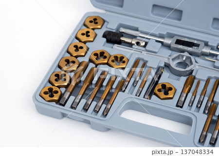 Professional tap and die set with titanium coating for thread cutting in a gray storage case. Professional tap and die set with titanium coating for thread cutting in a gray storage case. 137048334