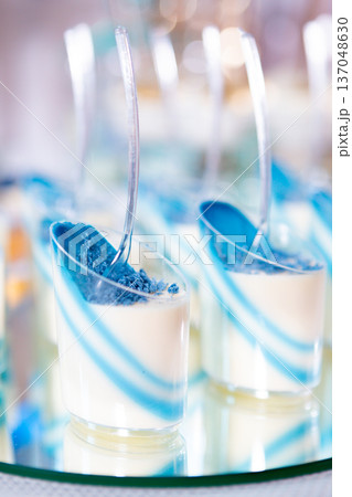 Colorful Dessert Cups With Blue and White Layers on a Reflective Surface at a Festive Event 137048630