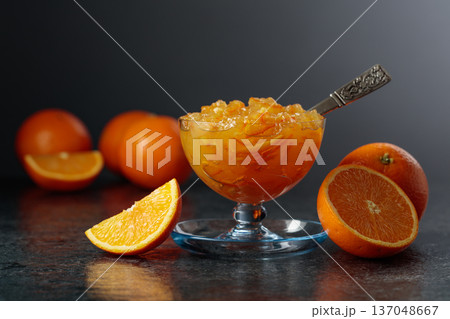 Homemade orange marmalade in a glass bowl on a black background. Homemade orange marmalade in a glass bowl on a black background. 137048667