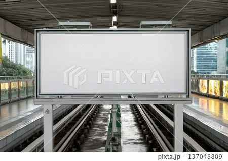 Blank billboard at the station, perfect for mock-up and advertising design. Urban setting with modern transportation and city life in the background 137048809