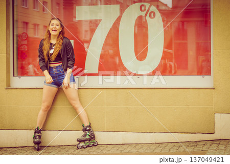 Woman wearing roller skates next to sale Woman wearing roller skates next to sale 137049421
