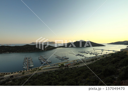 View from the bird's eye of the Kas city district of Antalya Province of Turkey Asia. Colorful spring sunset in small Mediterranean yachting and tourist town. View from the bird's eye of the Kas city district of Antalya Province of Turkey Asia. Colorful spring sunset in small Mediterranean yachting and tourist town. 137049470
