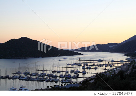 View from the bird's eye of the Kas city district of Antalya Province of Turkey Asia. Colorful spring sunset in small Mediterranean yachting and tourist town. View from the bird's eye of the Kas city district of Antalya Province of Turkey Asia. Colorful spring sunset in small Mediterranean yachting and tourist town. 137049477