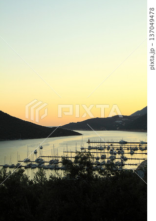 View from the bird's eye of the Kas city district of Antalya Province of Turkey Asia. Colorful spring sunset in small Mediterranean yachting and tourist town. 137049478