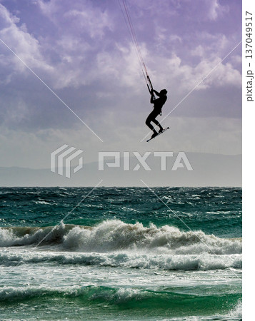Kite surfer riding waves. Kiteboarding sport. 137049517