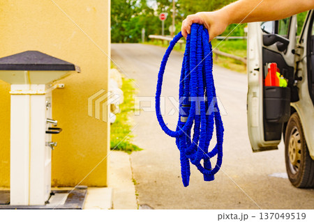 Caravan service. Hands hold hose to refilling rv water tank. Caravan service. Hands hold hose to refilling rv water tank. 137049519