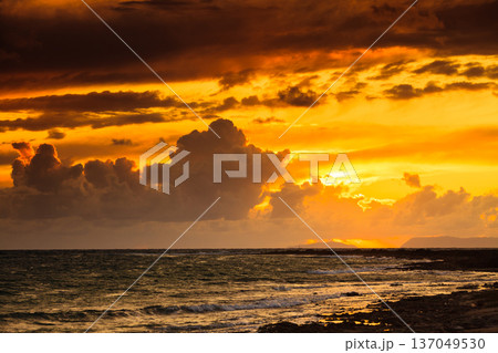 Sunset over sea surface, dark clouds. Sunset over sea surface, dark clouds. 137049530