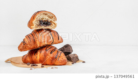 Stack of chocolate croissants with filling on light background 137049561