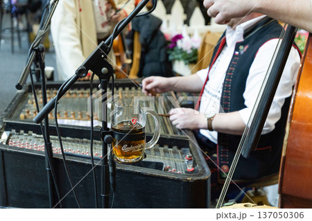 Berlin, Germany - January 19, 2024: Musicians performing with traditional instruments and beer Berlin, Germany - January 19, 2024: Musicians performing with traditional instruments and beer 137050306