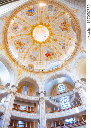 The Frauenkirche in Dresden shows its beautiful dome and detailed artwork. Visitors admire the interior of this historic church, a symbol of Dresden's culture and history. 137050770