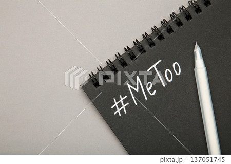 Hashtag METOO inscription white pen on black notebook on grey. Space for text 137051745