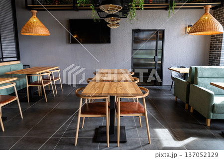 Contemporary restaurant interior with wooden tables and modern cozy dining area Contemporary restaurant interior with wooden tables and modern cozy dining area 137052129