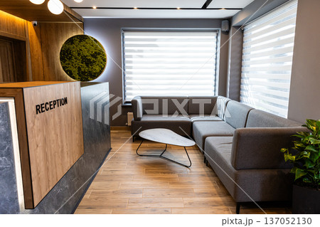 Modern hotel lobby waiting area with reception desk and comfortable seating interior Modern hotel lobby waiting area with reception desk and comfortable seating interior 137052130