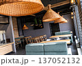 Stylish modern restaurant interior with wooden tables and rattan pendant lighting 137052132