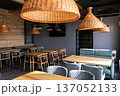 Stylish modern restaurant interior with wooden tables and rattan pendant lighting 137052133