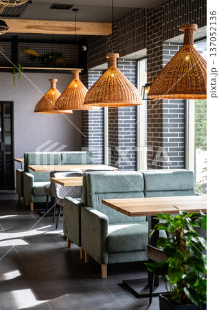 Modern cafe interior with cozy booths and rattan pendant lights in daylight Modern cafe interior with cozy booths and rattan pendant lights in daylight 137052136