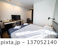 Cozy modern hotel bedroom with double bed fresh towels and soft natural window light 137052140