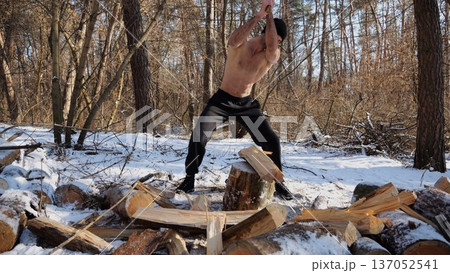 Shirtless strong man chopping firewood in a sunny winter forest. Muscular guy working with axe in snowy woodland. Concept of strength, masculine, energy and harmony with nature during cold season Shirtless strong man chopping firewood in a sunny winter forest. Muscular guy working with axe in snowy woodland. Concept of strength, masculine, energy and harmony with nature during cold season 137052541