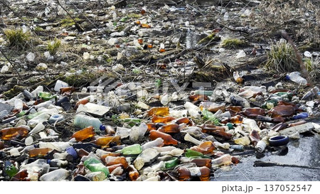 Dirty river is polluted with many plastic bottles. A lot of trash is dumped in open and freely available places at nature. Global environmental pollution problem. Concept of ecological disaster 137052547