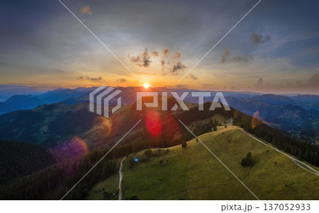 Old peasant home on hillside. Amazing mountain landscape. Bright colorful sunset in wild national park highlands. Dark spruce woods illuminated with yellow setting sun Old peasant home on hillside. Amazing mountain landscape. Bright colorful sunset in wild national park highlands. Dark spruce woods illuminated with yellow setting sun 137052933