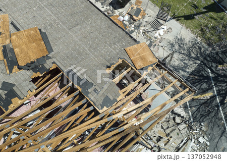 Wind damaged house roof with missing asphalt shingles after hurricane Ian in Florida. Repair of home rooftop concept Wind damaged house roof with missing asphalt shingles after hurricane Ian in Florida. Repair of home rooftop concept 137052948